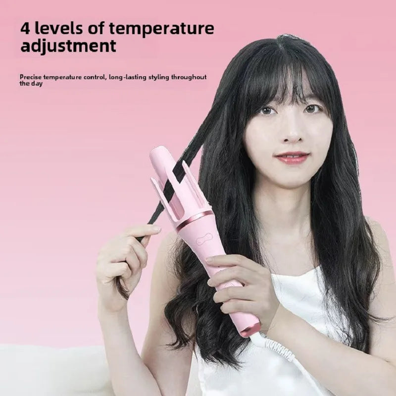 A woman is holding a pink automatic hair curling iron, demonstrating its temperature adjustment feature.