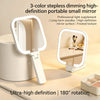 A portable small mirror with 3-color dimming features and an 180 degree rotation shown on a light surface.