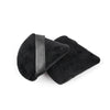 A pair of black velvet powder puffs with black leather straps.