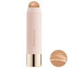 A tube of liquid bronzer contour foundation stick with a pink body and a nude top, shown against a white background.