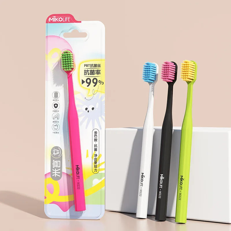 A pack of five pink and green soft bristle manual toothbrushes in individual packaging.