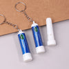 A set of blue nasal inhaler sticks with metal chains displayed on a brown background.