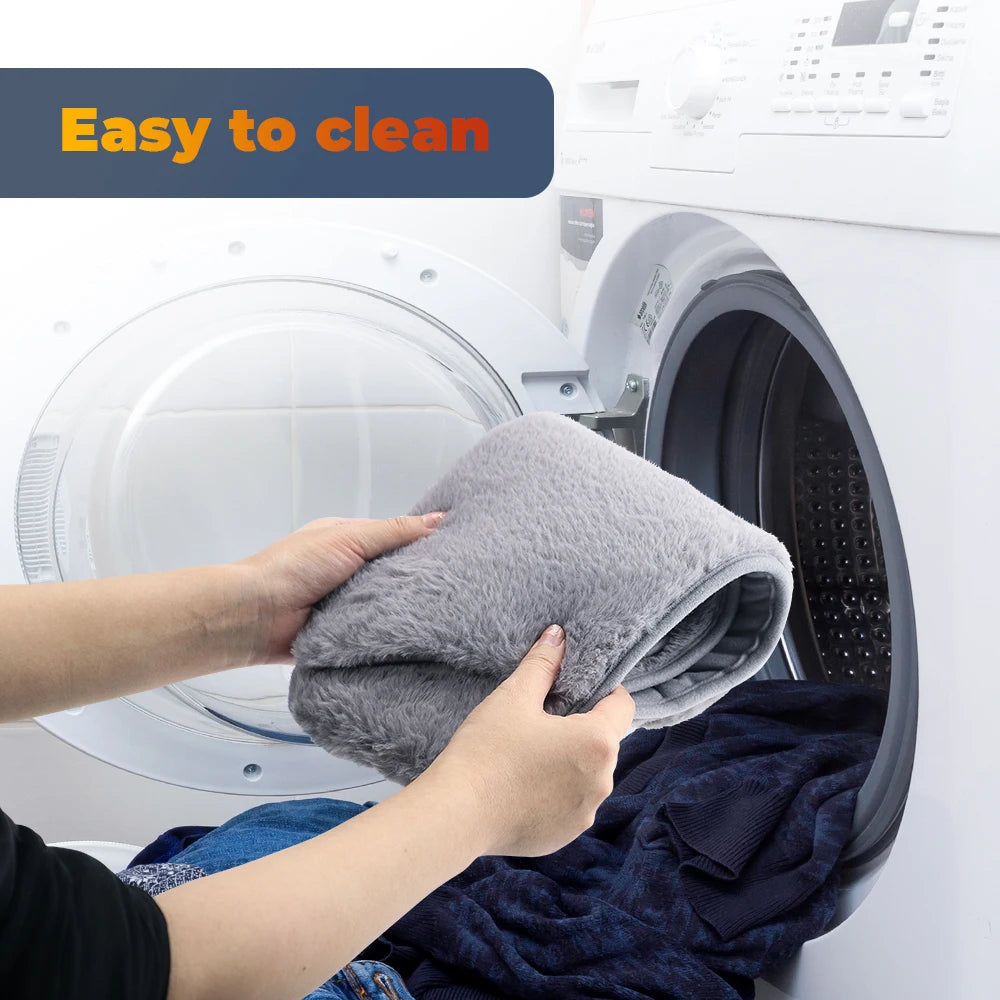 Hands are cleaning a white electric heating therapy belt inside a washing machine drum.