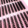 A close-up of black lash clusters applied to pink false lashes for dramatic eye looks.