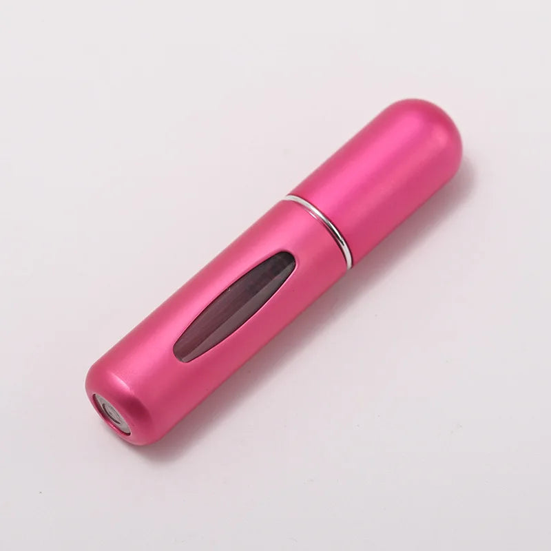 A pink portable refillable perfume bottle with a silver band, shown in a diagonal view.
