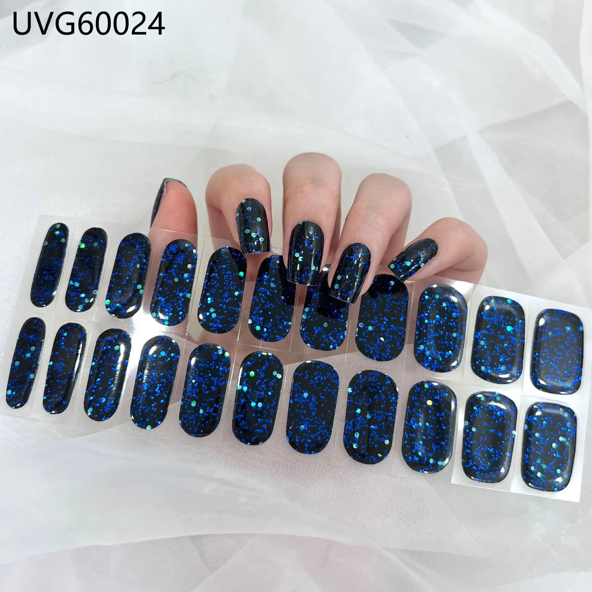 A set of dark blue glitter UV gel nail stickers for full coverage decals displayed on a hand.