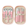 A pink storage case holds a stainless steel nail clipper set with various tools like scissors and tweezers.