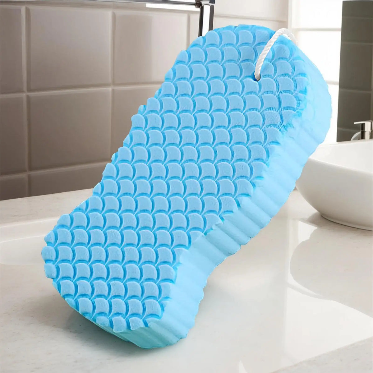 A bright blue exfoliating bath sponge is shown on a white countertop.
