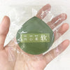 A green makeup puff set with a label in Chinese characters is held in a clear plastic bag.
