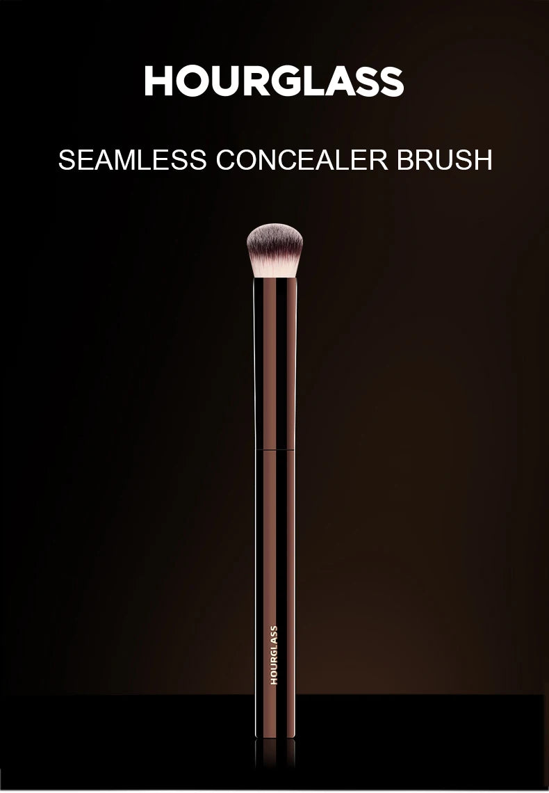 Un pinceau de correcteur sans couture Hourglass long et fin, de teinte rose gold, est exposé sur un fond sombre.