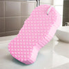 A pink exfoliating bath sponge set with a textured surface resting on a white countertop.