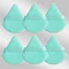 Un set de six éponges de maquillage triangulaires turquoise claires avec des élastiques.