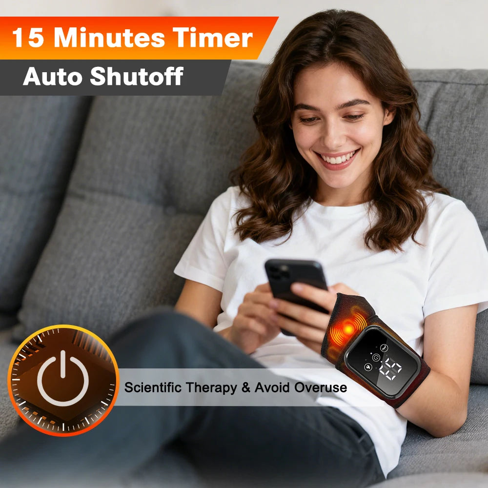 A woman is using a heated vibration wrist brace massager while relaxing on a couch.