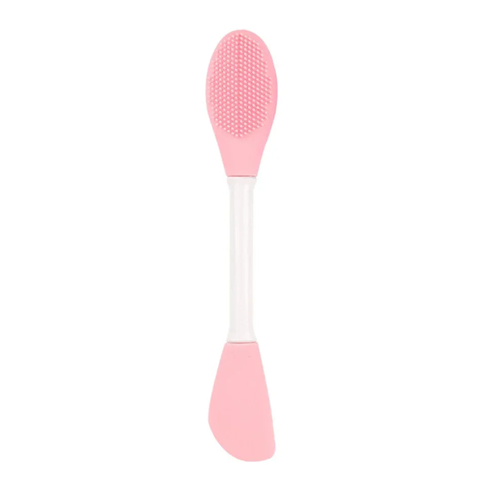 Cepillo facial de silicona rosa para limpieza y mascarilla con cabeza redondeada y mango largo.