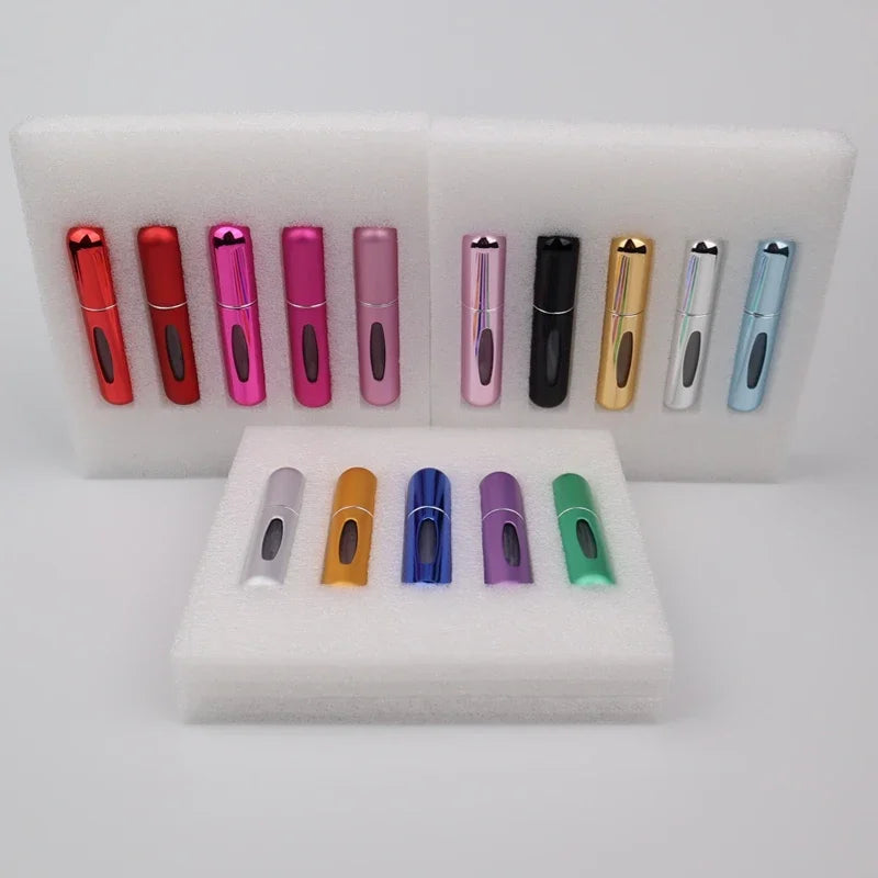 A set of five colorful 5ml travel perfume atomizer refillable mini spray bottles displayed in white foam trays.