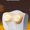 A white electric massage pillow with a warm light is shown resting on an orange textured surface.