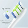 A white toothbrush with multiple replacement tip bristles in blue and green colors shown on a white background.