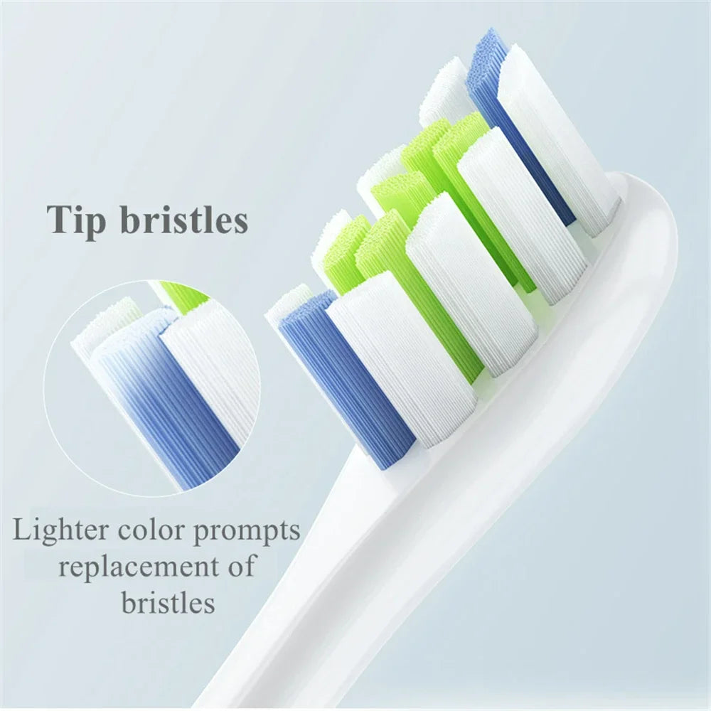 A white toothbrush with multiple replacement tip bristles in blue and green colors shown on a white background.