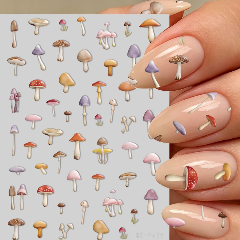 Close-up of a hand displaying watercolor mushroom nail art stickers on a fingernail.