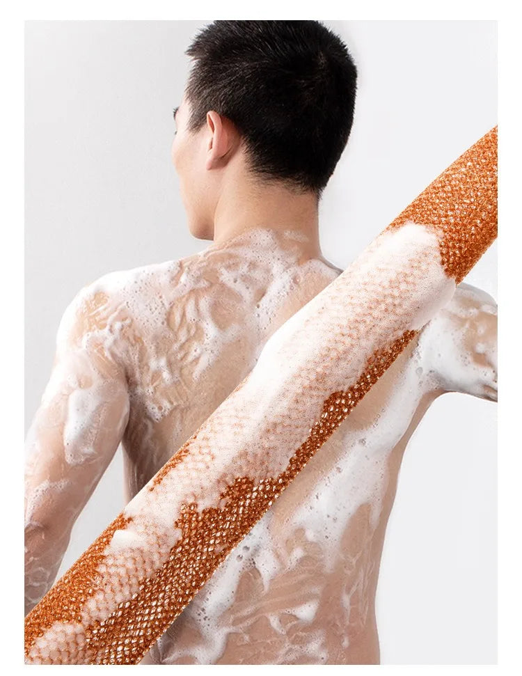 A person's back is shown with a white exfoliating sponge covered in brown scrub particles.