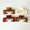 Three non-slip hat claw clips in leopard print and solid cream color.
