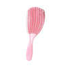 A pink massage detangler hair brush with numerous fine bristles for styling curly and thick hair.