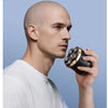 A man holding an electric rechargeable hair trimmer for facial and body grooming.