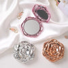 A pink vintage rose design double-sided pocket makeup mirror is shown with a silver and gold rose-shaped compact.