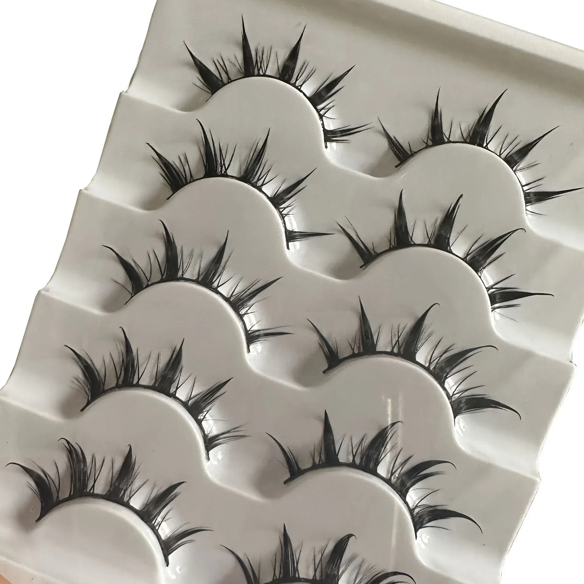 A set of anime-inspired dramatic false eyelashes displayed on a white plastic tray.