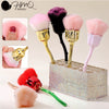 Un set de brochas de maquillaje con pelos sintéticos rosa, morado y negro, exhibidas en una caja decorativa.