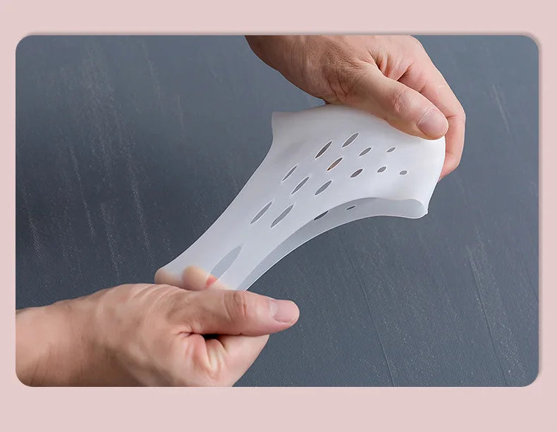 Une main place une semelle en silicone pour augmenter la hauteur sur la plante d'un pied.