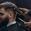 رجل يقوم بقص شعره باستخدام مجموعة ماكينة حلاقة لاسلكية احترافية.