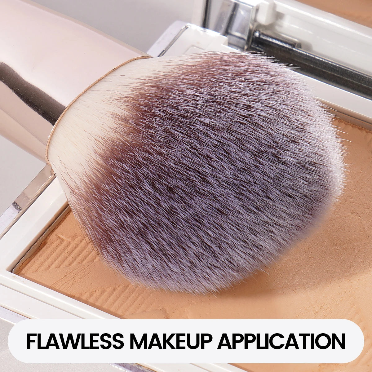 A close-up of a fluffy makeup brush with light gray and brown bristles resting on a wooden surface.