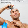 A man is shaving his head with a device while in the shower, demonstrating the IPX7 waterproof feature.