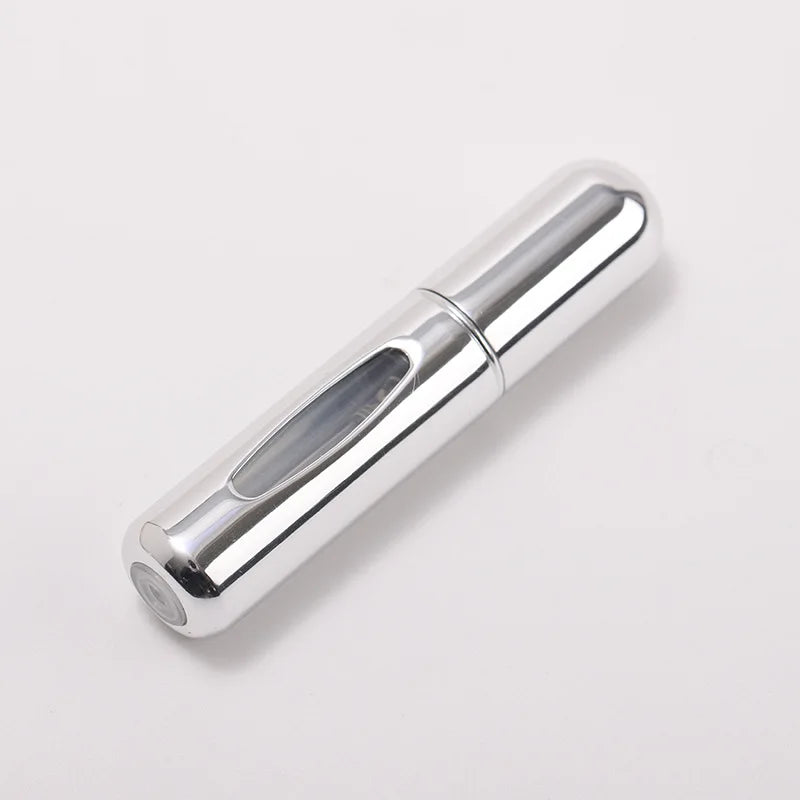A silver portable refillable perfume bottle shown in a side view against a white background.