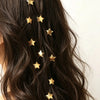 A close-up of dark hair adorned with ten gold star-shaped hairpins.