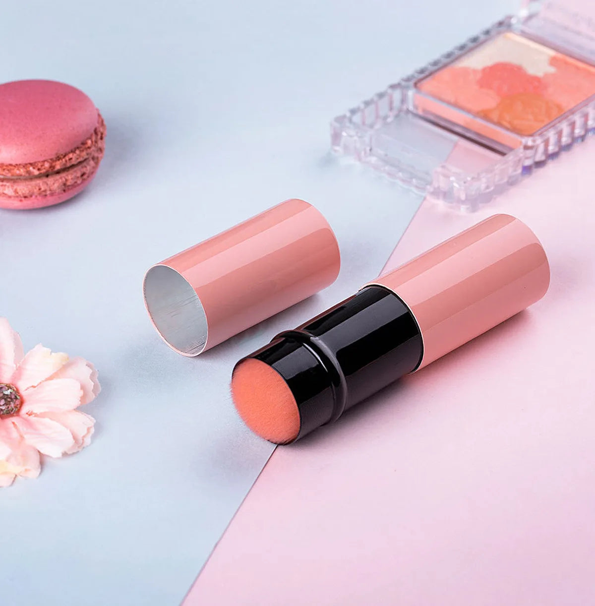 Ensemble de pinceaux de maquillage roses rétractables avec un pinceau rond et un pinceau plat, présenté sur une surface rose 