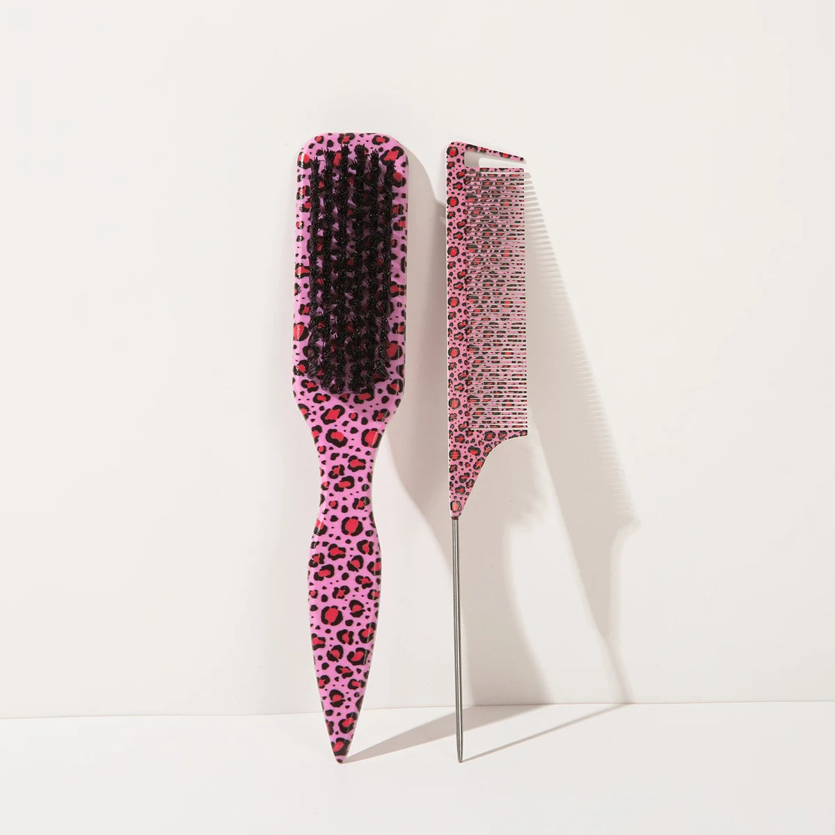 A set of two leopard print pointed tail hair combs, one black and one pink.
