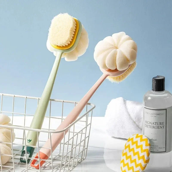 A long-handle loofah back scrubber with a soft mesh sponge is shown next to a round white sponge and a bottle of The Laundres