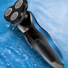 A black and blue multi-function electric shaver razor is shown against a bright blue, watery background.