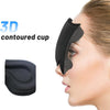 A close-up of a black 3D contoured cup sleep mask being placed on a person's face.
