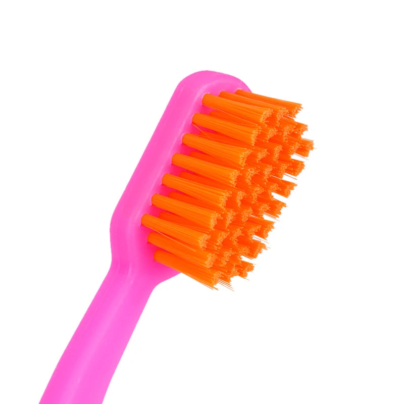 Une brosse orthodontique rose avec des poils fins orange vif sur fond blanc.