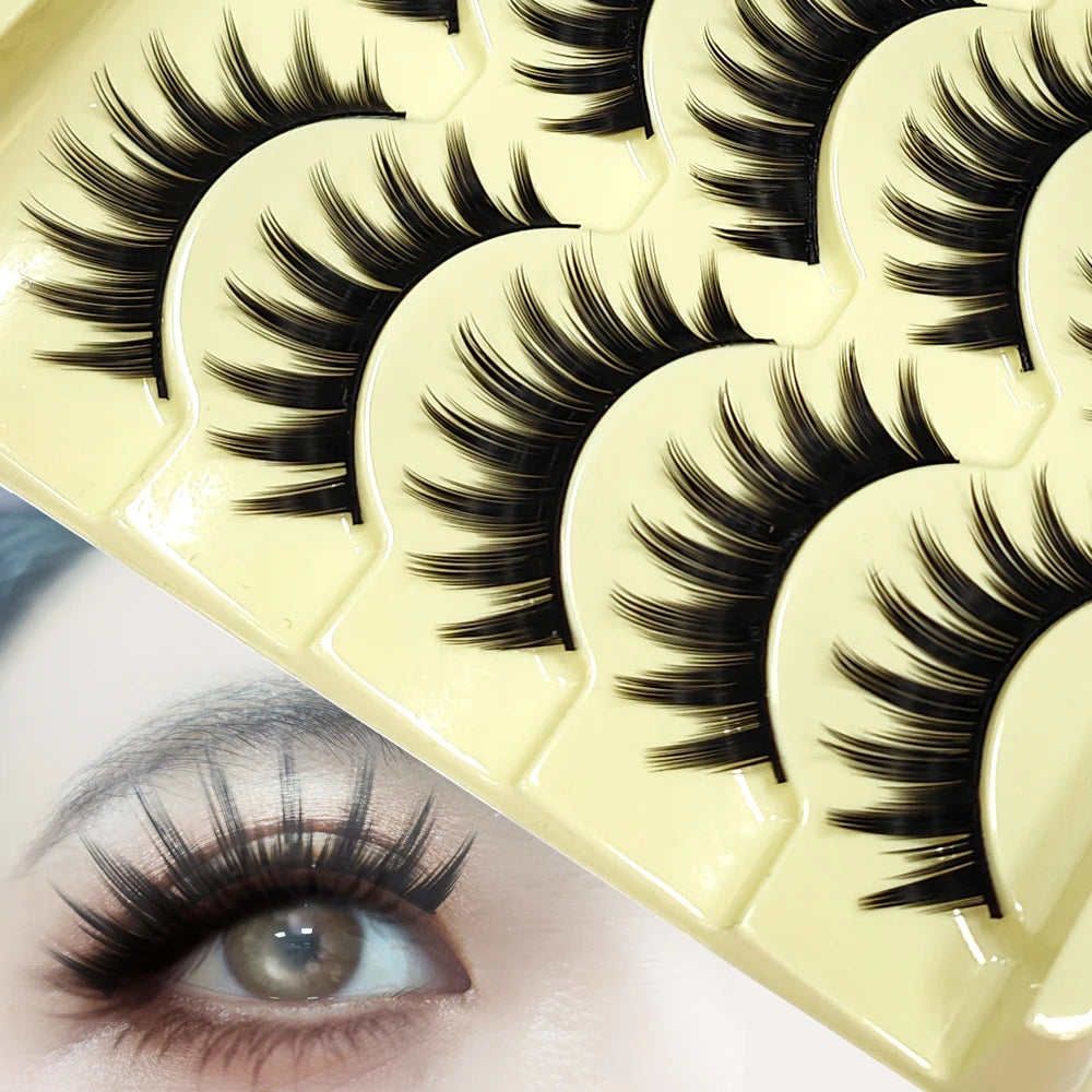 A close-up of a yellow false eyelash strip product showing several pairs of long black lashes.