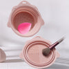 A pink silicone makeup brush cleaner and drying stand set with a mesh surface for cleaning brushes.