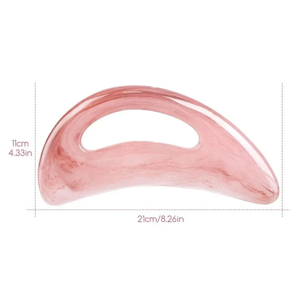A pink resin gua sha massage tool used for facial and body lymphatic drainage.