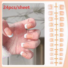 A hand displays a sheet of 24 press-on nails with nude pink base and white French tips.