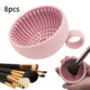 Eight silicone makeup brushes in a pink container with several brush heads shown alongside the cleaner