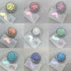 A collection of iridescent glitter powders in various shades, including mint green, pink, and blue, displayed in small glass 