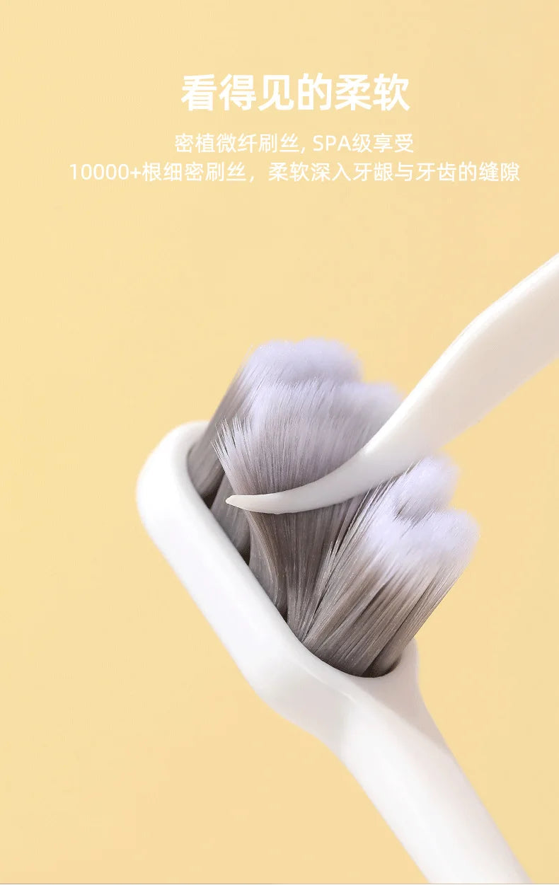 A close-up of a white toothbrush with soft gray bristles is shown against a light background.
