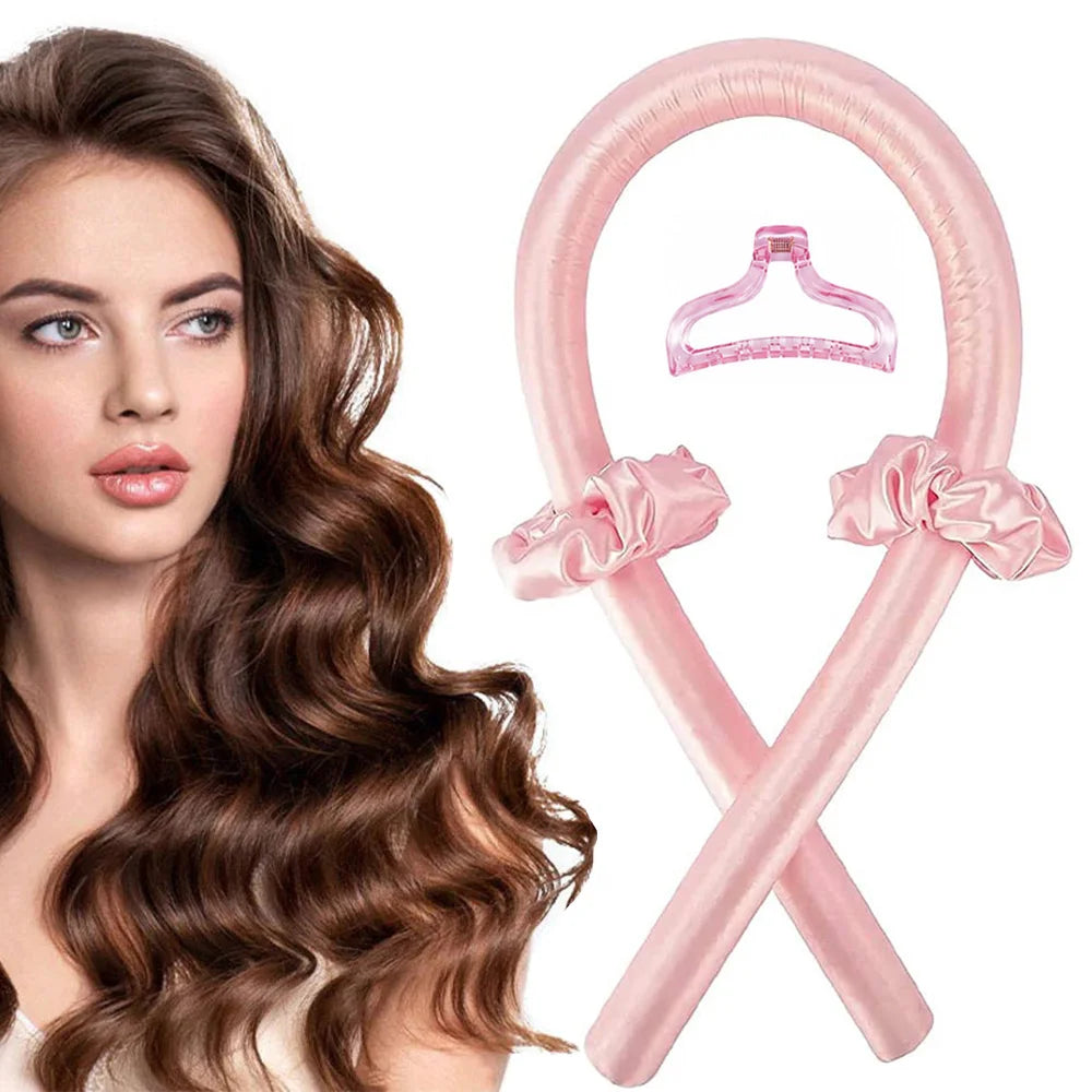 A pink satin heatless curling set with a bow is shown next to a woman's hair.